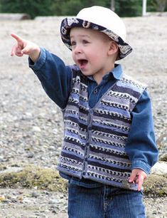 a young boy wearing a cowboy hat and vest pointing to the side with his finger