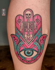 a tattoo on the leg of a person with a hand and eye in front of it