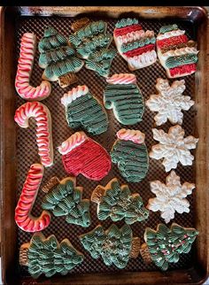 christmas cookies decorated with icing and candy canes on a cookie sheet in a baking pan