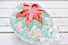 an ornament is sitting on top of a white table with beads and bows