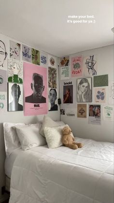 a white bed sitting in a bedroom next to a wall with pictures on the walls