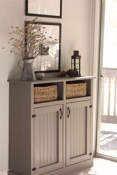 a gray cabinet with baskets on top and a mirror above it that says, our current home