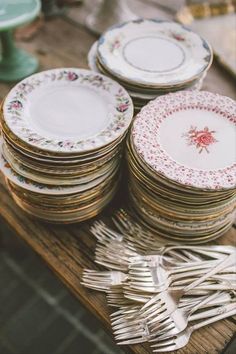 a pile of plates sitting on top of a wooden table