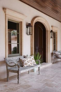 a wooden bench sitting on top of a tiled floor next to a door and windows