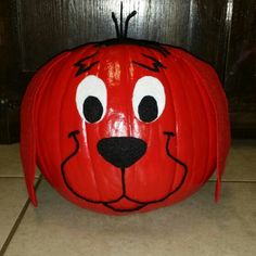 a pumpkin shaped like a dog's head with eyes and nose painted on it