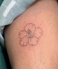 a small flower tattoo on the thigh