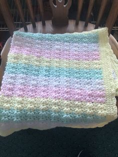 a crocheted blanket sitting on top of a wooden chair