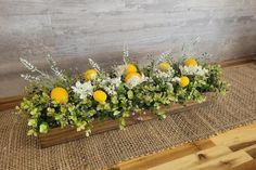 a wooden box filled with flowers and greenery