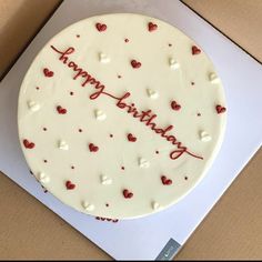 a birthday cake with hearts on it in a box