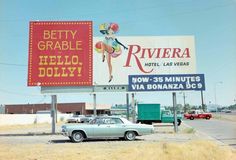 an old car is parked in front of a large sign for riviera hotel and las vegas