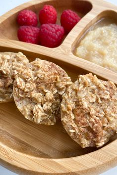 some food on a wooden plate with raspberries and oatmeal