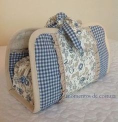 a blue and white checkered purse sitting on top of a bed next to a wall