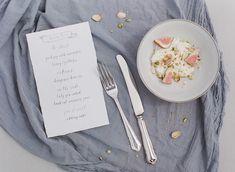 a table topped with a bowl of food next to a fork and paper on top of it