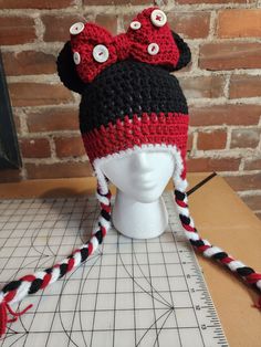 a crocheted hat with ears and eyes on top of a mannequin head