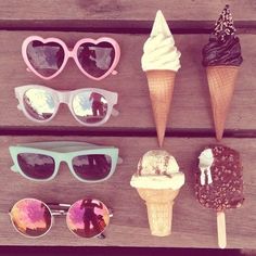 an assortment of ice cream and sunglasses sitting on a wooden table next to each other