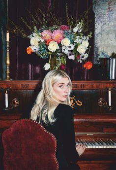 a woman sitting in front of a piano