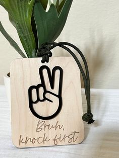 a wooden sign with the word rock and roll written on it next to a potted plant