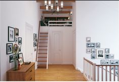 there is a staircase leading up to the second floor with pictures on the wall and below it