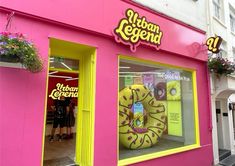 a pink store front with a giant donut in the window