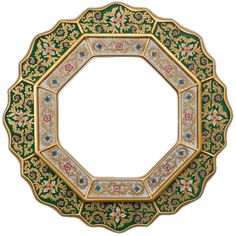 an ornate green and gold plate with flowers on the border, surrounded by smaller floral designs