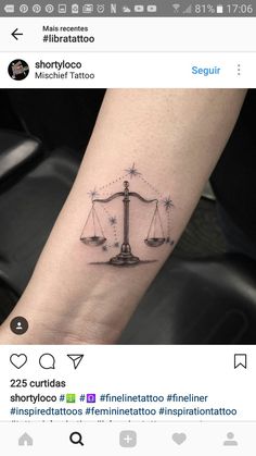 a tattoo on the arm of a person with a scale of justice tattooed on it