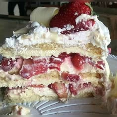 a piece of cake with strawberries and whipped cream on top