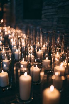 many white candles are lit on a table