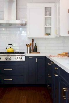 a kitchen with white and blue cabinets and wood flooring, along with wooden floors