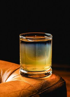 a shot glass sitting on top of a leather chair