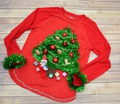 a christmas tree made out of tinsel and other decorations on top of a red sweater