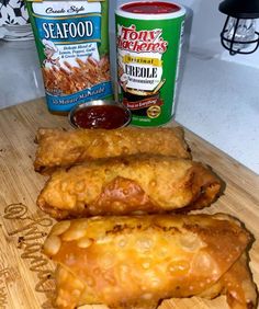 some food is laying out on a cutting board next to two cans of seafood