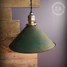 a green light hanging from a wooden wall