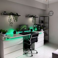 a white desk topped with a computer monitor next to a green plant filled desktop screen