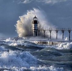 a lighthouse surrounded by waves in the ocean