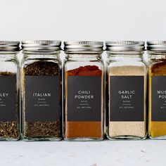 five jars filled with different types of spices