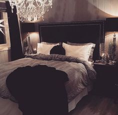 a bedroom with a chandelier hanging from the ceiling and a bed in it