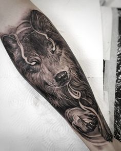 a man's arm with a wolf tattoo on it