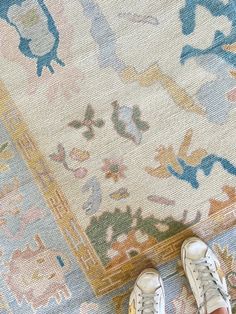 a person standing on top of a rug with their feet propped up against the carpet