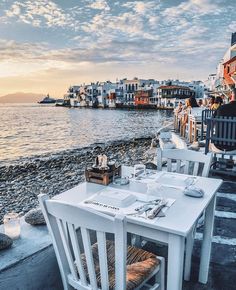 an outdoor dining area next to the water