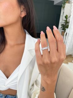 a woman wearing a white shirt and a diamond ring