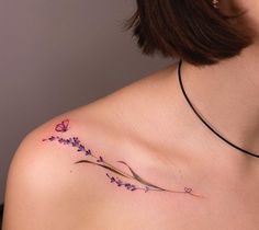 a woman with a tattoo on her shoulder has flowers in the shape of a butterfly