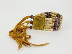 "This Iroquois bone bracelet is made by Iroquois women on the Six Nations Reservation in Ontario, Canada. The bead colors vary, so please let us know if you have a color preference when you order or we will ship a random color. The length is adjustable from 8\" - 12\". Width is 1.5\". This traditional Iroquois bone jewelry is made with deerskin leather, cow bone hairpipe, brass and glass beads. Native Made in Canada A USFWS export permit is required for all shipments outside the USA. Genus and s Adjustable Bone-colored Bracelet, Bone Bracelet, Bones Bracelet, Cow Bones, Six Nations, Bone Jewelry, Deer Skin, Random Color, Ontario Canada