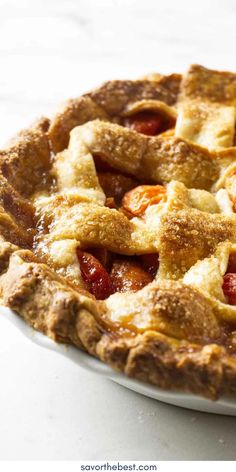 a close up of a pie on a white plate with fruit in the crust and toppings