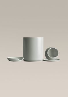 a white cup and saucer sitting next to each other on top of a table