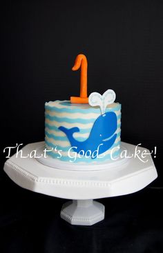 a blue and white cake with an orange number one on it's icing