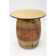 a wooden barrel table sitting on top of a white floor