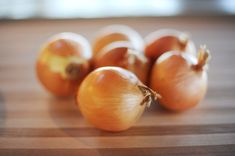 some onions are sitting on a wooden table