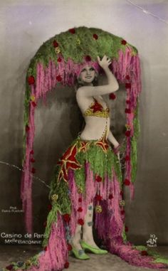 an old photo of a woman dressed as a hula dancer in pink and green