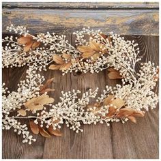 a white flower and leaf headband on a wooden surface