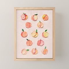 an art piece with peaches cut into pieces in a wooden frame on a wall